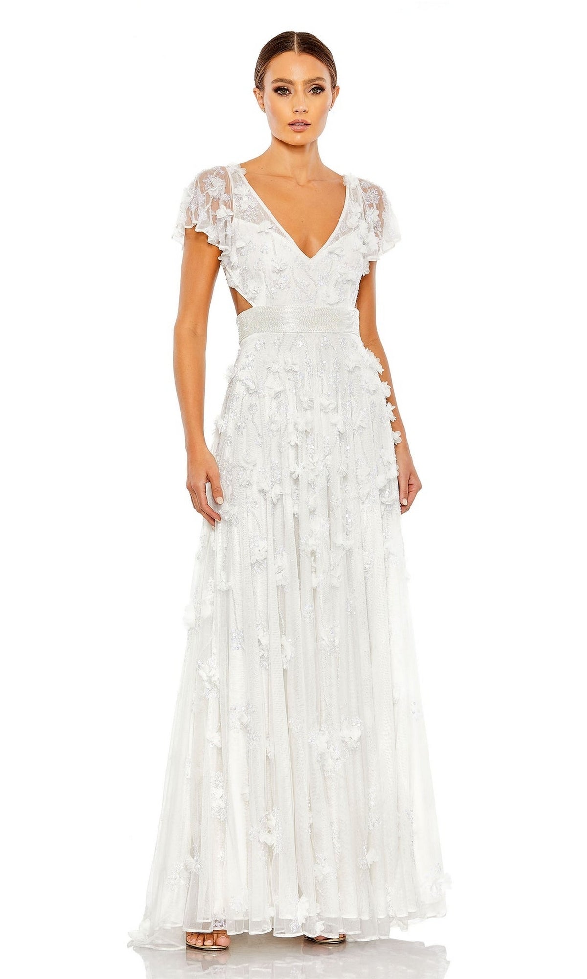 A woman wears the Long Formal Dress 70275 by Mac Duggal—an A-line, floor-length white gown with short sheer sleeves, deep V-neckline, fitted waist, and floral appliqué details—standing against a plain white background.